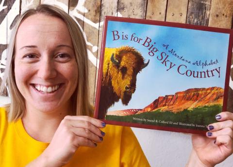 Annika holding a book called B is for Big Sky