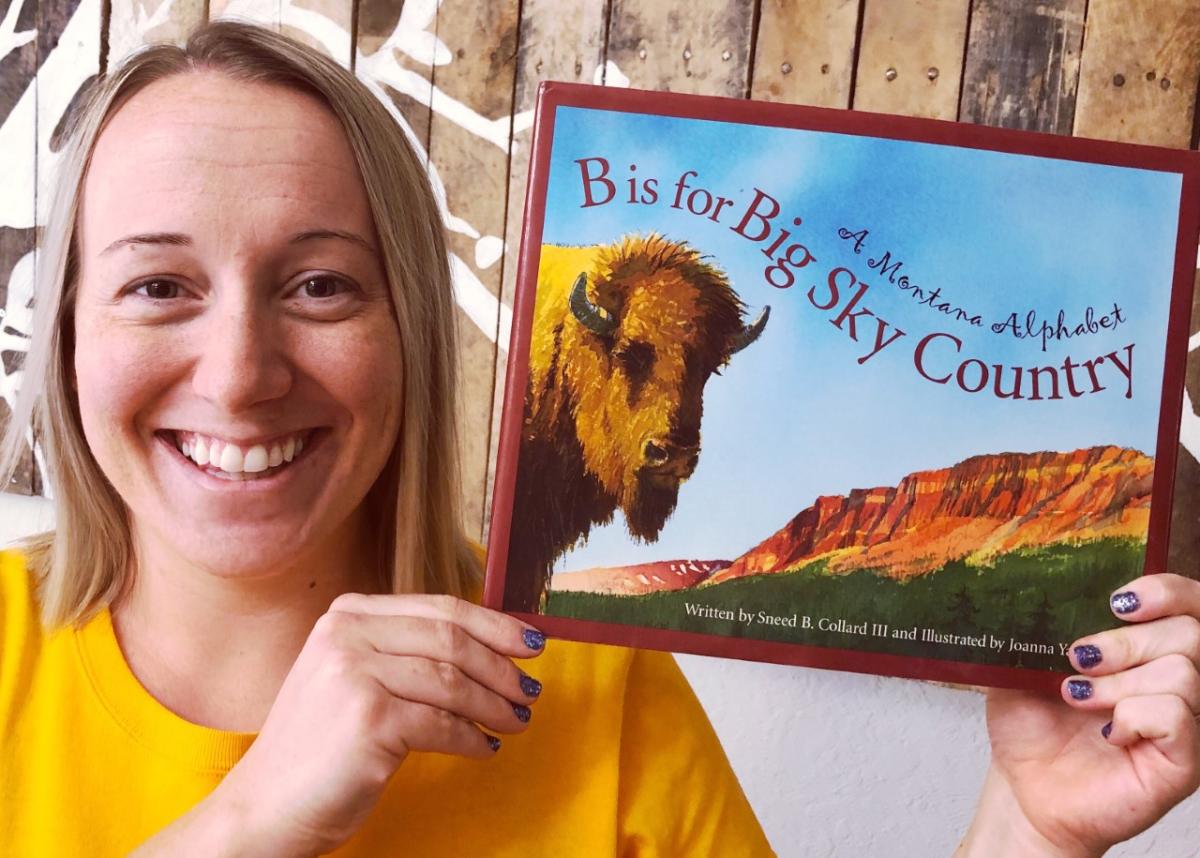 Annika holding a book called B is for Big Sky