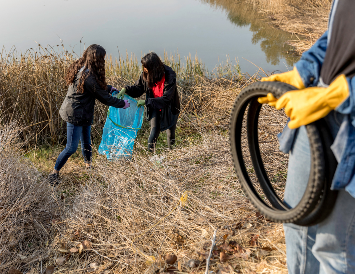 people cleaning up trash by river