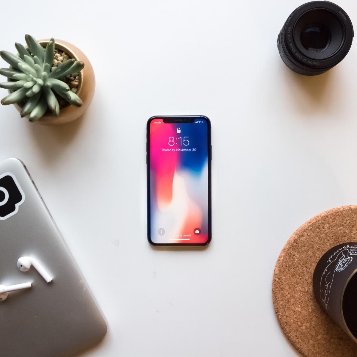 iPhone sitting on table next to houseplant